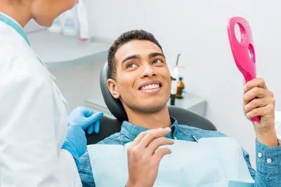 man loving the look of his smile after getting dental crowns at Stonebriar Family Dentistry in Frisco, TX