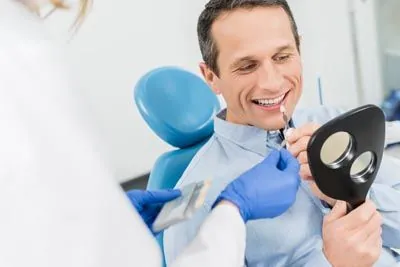 man choosing what color dental veneer he'd like during his visit to Stonebriar Family Dentistry in Frisco, TX