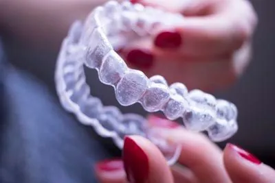 patient holding their clear aligners they got at Stonebriar Family Dentistry in Frisco, TX